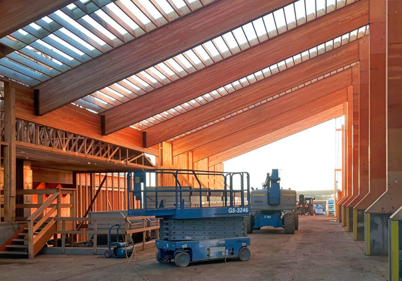 Looking up at large exposed wooden pillars and beams from a Northern Legendary Construction Ltd. project while it was underway in Dawson Creek, BC.